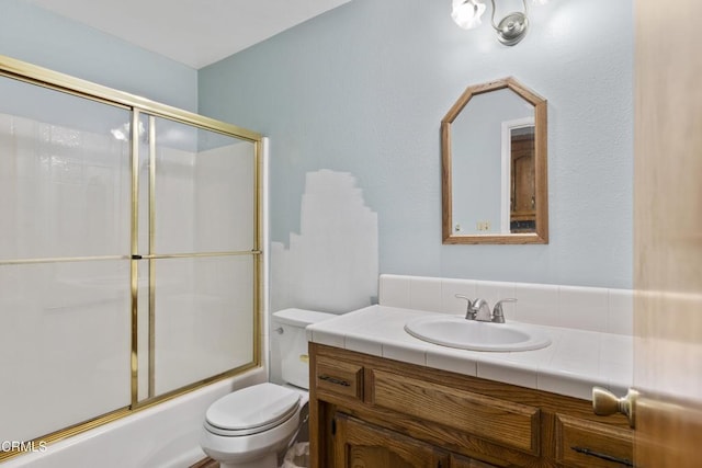 bathroom featuring toilet, vanity, and enclosed tub / shower combo