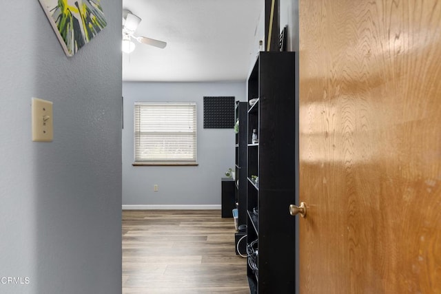 corridor with wood finished floors and baseboards