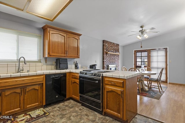 kitchen with dishwasher, a peninsula, stove, a sink, and ceiling fan