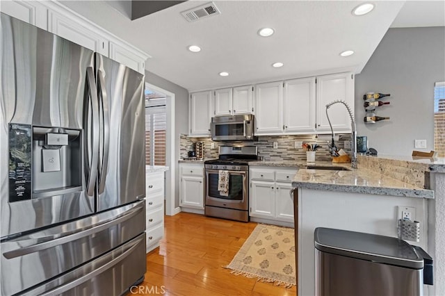 41488 Yankee Run Ct, Temecula, CA 92591 - kitchen featuring appliances with stainless steel finishes, a sink, white cabinets, a peninsula, and recessed lighting
