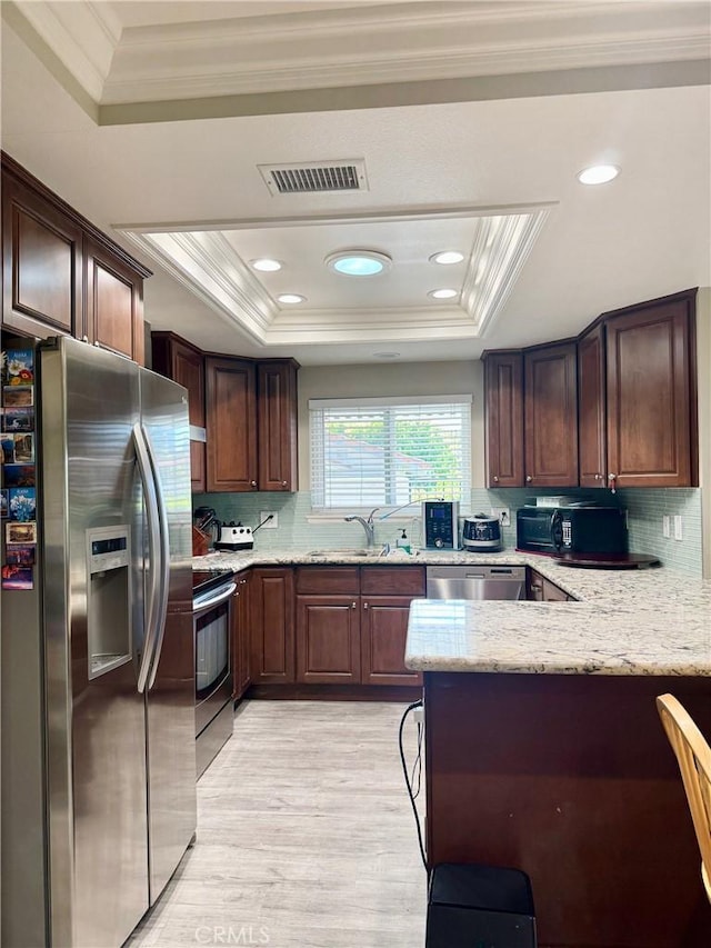 2147 Ronda Granada Unit A, Laguna Woods, CA 92637 - kitchen with appliances with stainless steel finishes, a tray ceiling, ornamental molding, a sink, and a peninsula