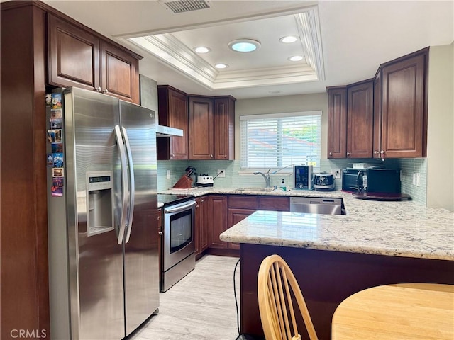 2147 Ronda Granada Unit A, Laguna Woods, CA 92637 - kitchen featuring stainless steel appliances, a sink, a peninsula, a raised ceiling, and light wood-style flooring