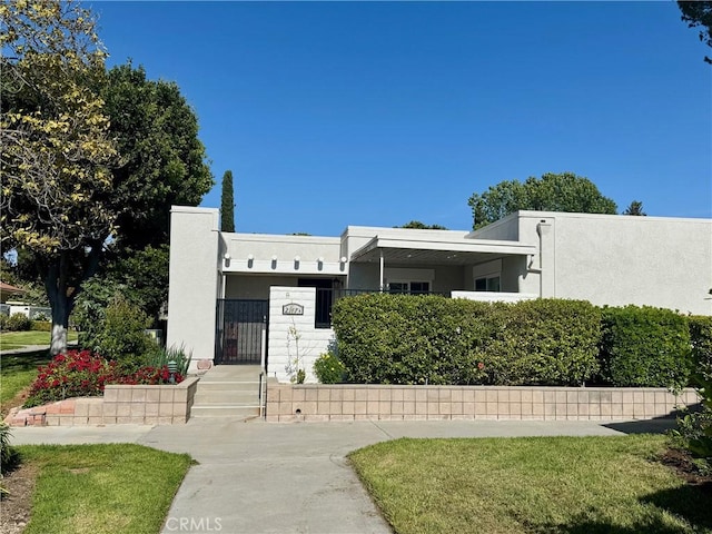2147 Ronda Granada Unit A, Laguna Woods, CA 92637 - view of front of house with stucco siding, a fenced front yard, and a gate