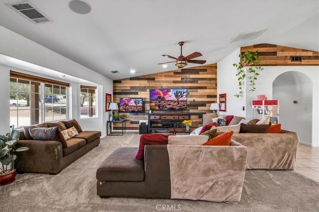 7356 Rubidoux Ave, Yucca Valley, CA 92284 - living room with lofted ceiling, wood walls, ceiling fan, arched walkways, and tile patterned flooring