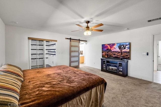 7356 Rubidoux Ave, Yucca Valley, CA 92284 - carpeted bedroom with a barn door, a ceiling fan, and baseboards