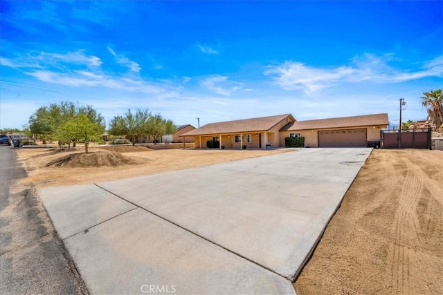 7356 Rubidoux Ave, Yucca Valley, CA 92284 - ranch-style home with an attached garage, concrete driveway, fence, and stucco siding