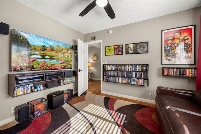 office space with a ceiling fan, baseboards, a textured ceiling, and carpet flooring