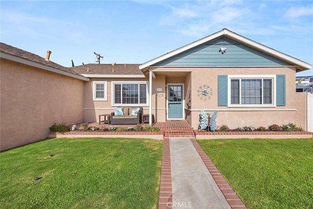 view of front of home with an outdoor hangout area, a front yard, and stucco siding
