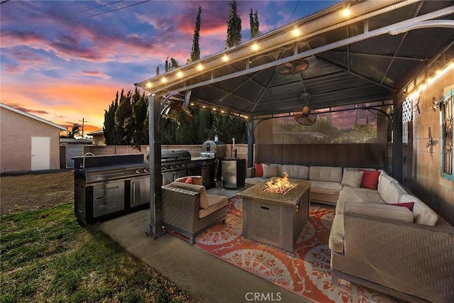 view of patio / terrace featuring an outdoor living space with a fire pit, an outdoor kitchen, a gazebo, and grilling area