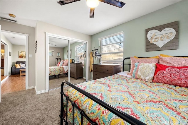 bedroom featuring light colored carpet, a closet, ceiling fan, and baseboards