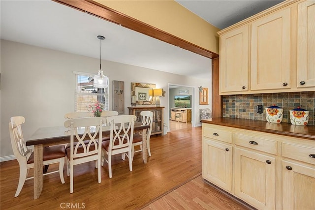 dining space featuring light wood-type flooring and baseboards
