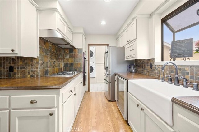 1418 S Cedar Ave, Fullerton, CA 92833 - kitchen with stacked washer / dryer, stainless steel gas cooktop, a sink, wall chimney range hood, and dishwashing machine