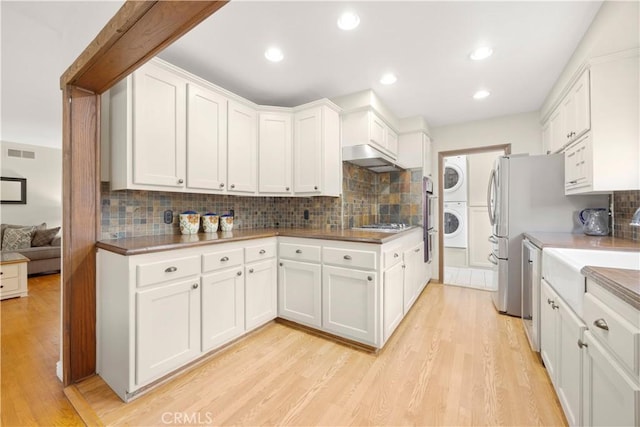 1418 S Cedar Ave, Fullerton, CA 92833 - kitchen featuring stacked washer / drying machine, tasteful backsplash, light wood-type flooring, white cabinetry, and recessed lighting