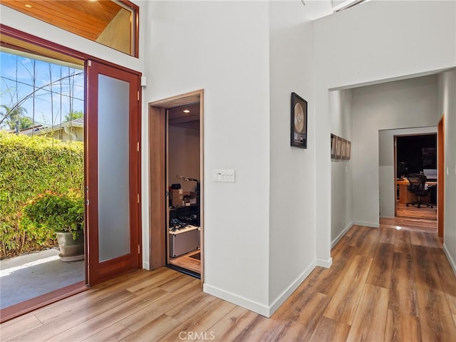 5762 Andasol Ave, Encino, CA 91316 - hallway featuring light wood finished floors, a high ceiling, and a desk