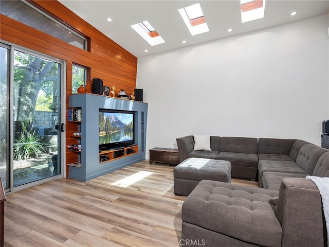 5762 Andasol Ave, Encino, CA 91316 - living room featuring a skylight, light wood-type flooring, high vaulted ceiling, wooden walls, and recessed lighting