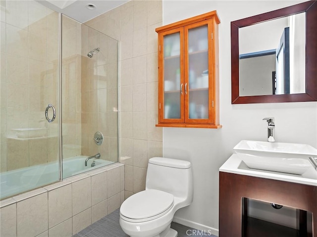bathroom featuring tiled shower / bath combo, toilet, tile patterned flooring, vanity, and baseboards