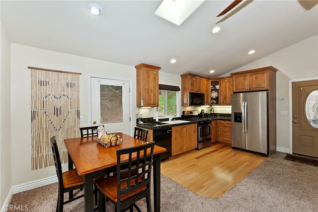 23776 Lakeview Dr, Crestline, CA 92325 - kitchen with black appliances, dark countertops, light colored carpet, glass insert cabinets, and a skylight