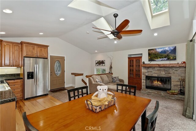 23776 Lakeview Dr, Crestline, CA 92325 - dining area featuring a skylight, lofted ceiling, a ceiling fan, a fireplace, and recessed lighting