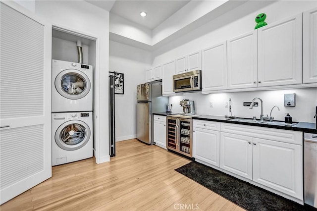 1401 Mission St Unit 105, South Pasadena, CA 91030 - kitchen with appliances with stainless steel finishes, stacked washer / drying machine, dark countertops, beverage cooler, and white cabinetry