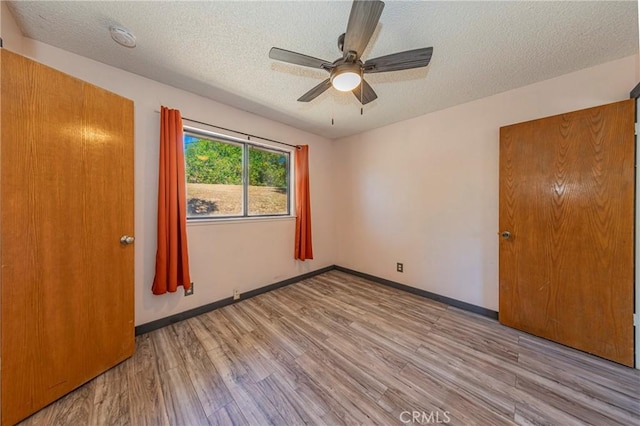 43096 Deer Trail Way, Coarsegold, CA 93614 - unfurnished bedroom featuring a textured ceiling, wood finished floors, ceiling fan, and baseboards