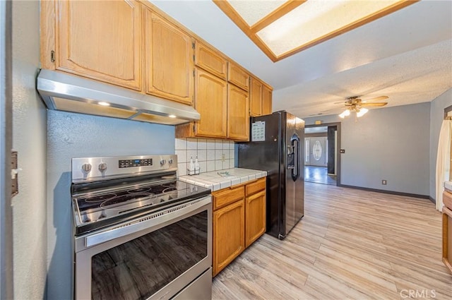 43096 Deer Trail Way, Coarsegold, CA 93614 - kitchen with stainless steel electric range oven, under cabinet range hood, black refrigerator with ice dispenser, tile counters, and backsplash