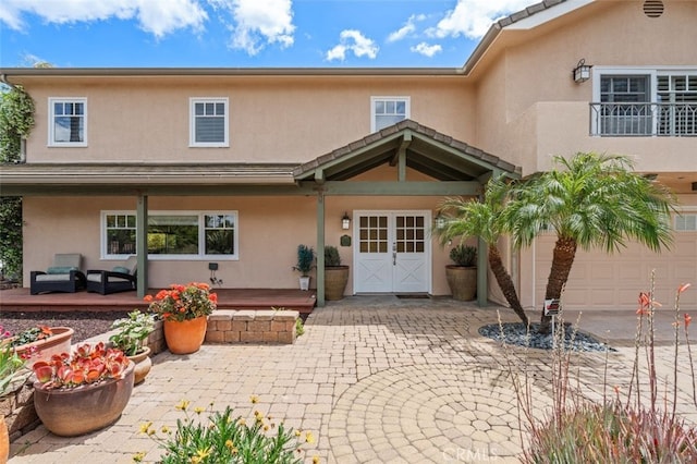 rear view of house with stucco siding, outdoor lounge area, and driveway