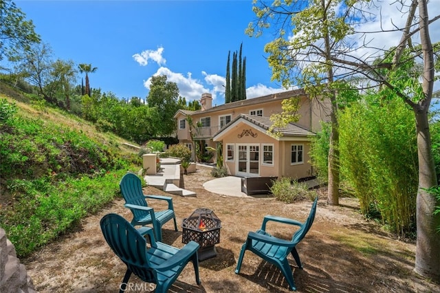 back of property featuring an outdoor fire pit, a patio area, a balcony, a jacuzzi, and stucco siding