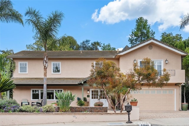 view of front of house featuring a garage, stucco siding, and decorative driveway