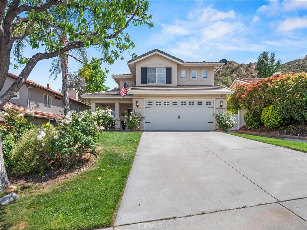 28042 Cascade Rd, Castaic, CA 91384 - traditional-style house featuring an attached garage, driveway, a front lawn, and stucco siding