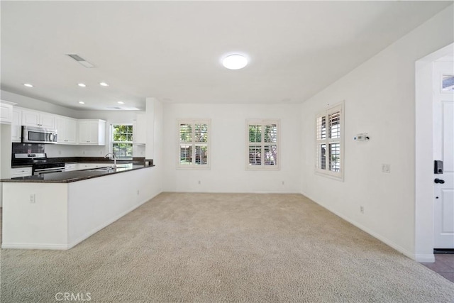 3933 E Bethany Way, Ontario, CA 91761 - kitchen featuring appliances with stainless steel finishes, light carpet, dark countertops, a peninsula, and recessed lighting