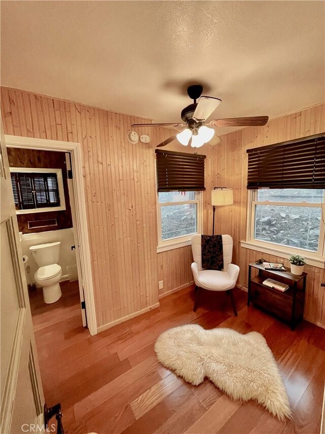 23739 Skyland Dr, Crestline, CA 92325 - sitting room with wood finished floors, ceiling fan, wooden walls, and baseboards