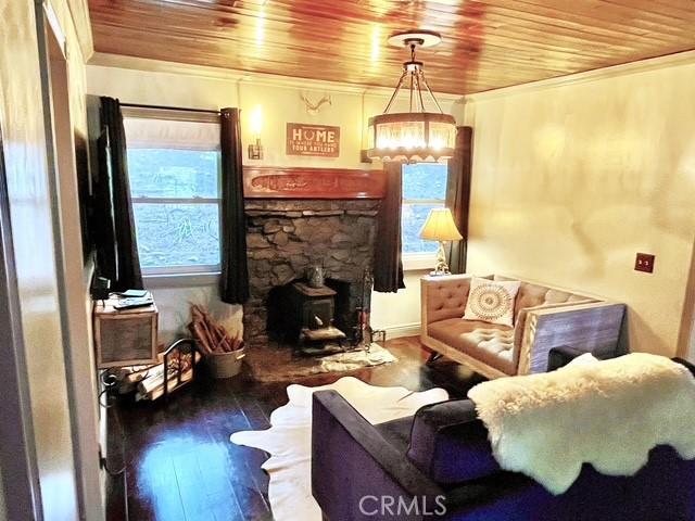 23739 Skyland Dr, Crestline, CA 92325 - living room with wood ceiling, ornamental molding, wood-type flooring, and a chandelier