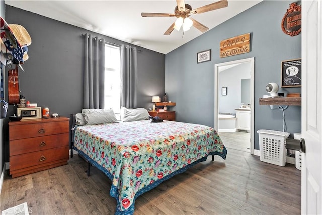 bedroom with wood finished floors, connected bathroom, ceiling fan, vaulted ceiling, and baseboards