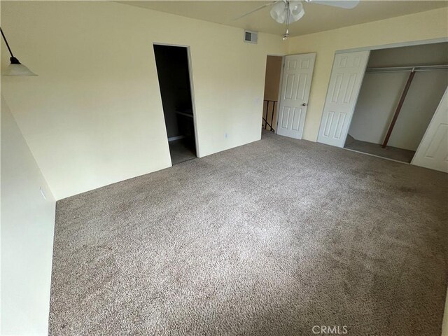 unfurnished bedroom with carpet, a closet, and ceiling fan