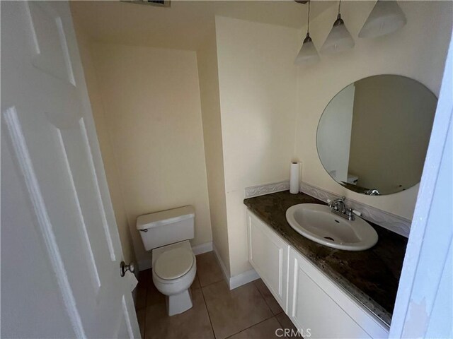 bathroom with toilet, tile patterned flooring, and vanity