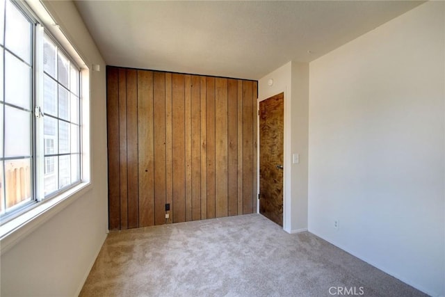 221 E Barker Blvd, Big Bear City, CA 92314 - empty room with wood walls, carpet flooring, and healthy amount of natural light