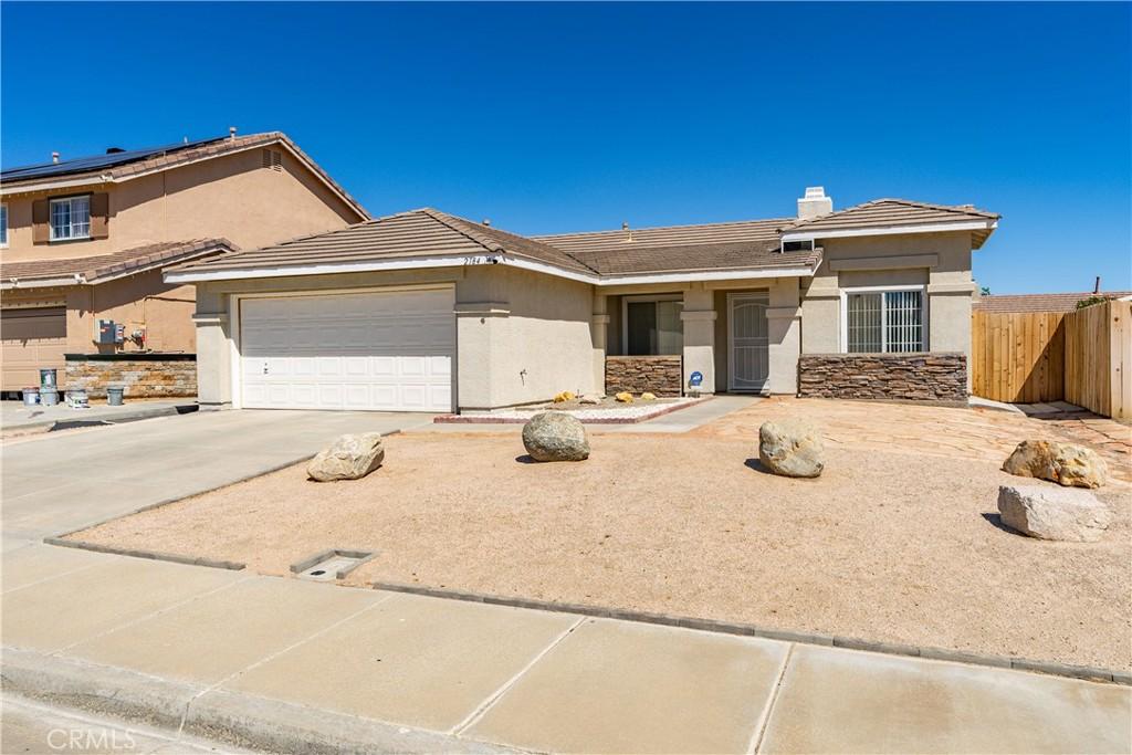 2184 Westpark Dr, Rosamond, CA 93560 - view of front of property with concrete driveway, fence, stucco siding, and an attached garage