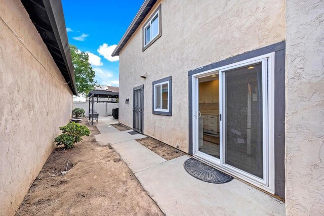 9560 Frank Way, Santee, CA 92071 - view of side of home featuring stucco siding, a patio, and fence
