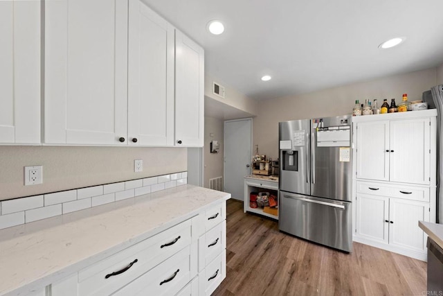 9560 Frank Way, Santee, CA 92071 - kitchen with stainless steel fridge with ice dispenser, light wood-type flooring, white cabinets, light stone countertops, and recessed lighting