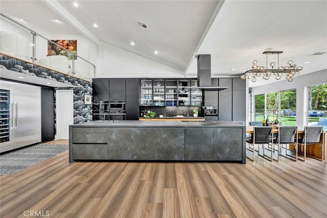 18782 Peppertree Dr, Villa Park, CA 92861 - kitchen with light wood-style flooring, island range hood, gray cabinetry, built in refrigerator, and glass insert cabinets