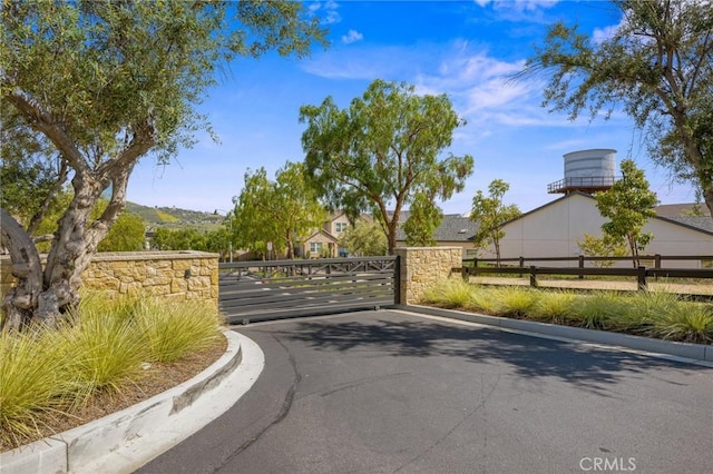 32404 Old Sage Dr, San Juan Capistrano, CA 92675 - view of asphalt street with a gate and curbs