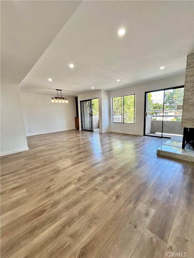 365 W Alameda Ave Unit 203, Burbank, CA 91506 - unfurnished living room with recessed lighting, light wood finished floors, and a stone fireplace