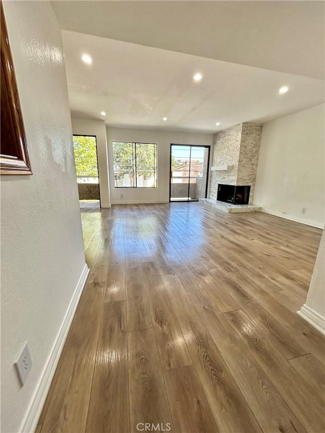 365 W Alameda Ave Unit 203, Burbank, CA 91506 - unfurnished living room featuring hardwood / wood-style floors, recessed lighting, and a stone fireplace