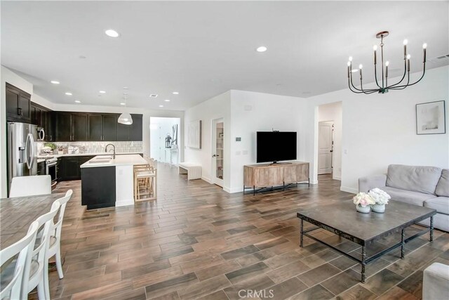 11837 Terra Vista Way, Sylmar, CA 91342 - living room featuring recessed lighting, a chandelier, baseboards, wood finished floors, and radiator