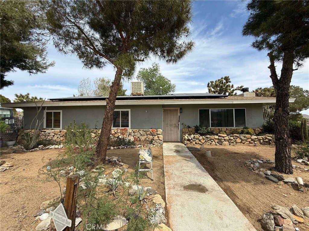 56484 Onaga Trl, Yucca Valley, CA 92284 - ranch-style house with stucco siding, stone siding, and solar panels