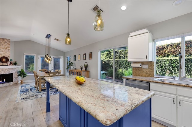 24632 Stagg St, West Hills, CA 91304 - kitchen with lofted ceiling, light wood finished floors, a center island, dishwasher, and white cabinetry