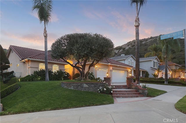 24632 Stagg St, West Hills, CA 91304 - view of front of property with an attached garage, a front lawn, stucco siding, a tile roof, and driveway