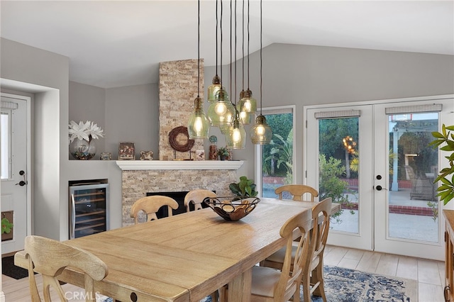 24632 Stagg St, West Hills, CA 91304 - dining space with beverage cooler, french doors, lofted ceiling, light wood-style flooring, and a stone fireplace