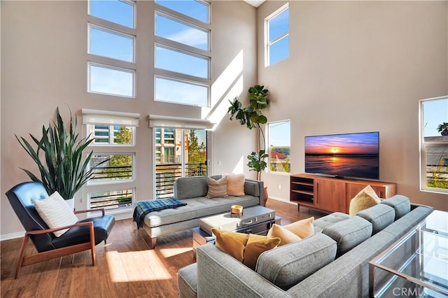 1508 W Artesia Unit H, Gardena, CA 90248 - living area with a towering ceiling, wood-type flooring, and baseboards