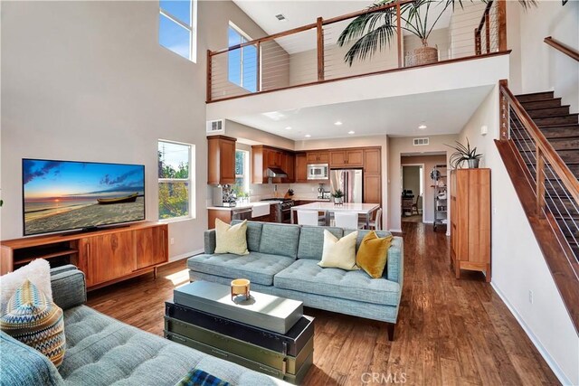 1508 W Artesia Unit H, Gardena, CA 90248 - living room with a towering ceiling, stairway, baseboards, dark wood-style floors, and recessed lighting